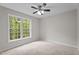Bright bedroom with a large window showcasing outdoor views and a modern ceiling fan at 1106 Lake Ridge Dr, Creedmoor, NC 27522