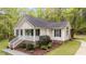 A beautiful home with a cozy front porch and landscaped front yard nestled in a wooded area at 1106 Lake Ridge Dr, Creedmoor, NC 27522