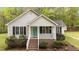 Charming home featuring a quaint front porch, a teal door, and meticulously landscaped garden beds at 1106 Lake Ridge Dr, Creedmoor, NC 27522