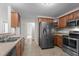 Functional kitchen featuring stainless steel appliances, wooden cabinetry and a stainless steel sink at 1106 Lake Ridge Dr, Creedmoor, NC 27522