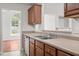 Well-lit kitchen featuring wood cabinetry, stainless steel sink, and modern appliances at 1106 Lake Ridge Dr, Creedmoor, NC 27522