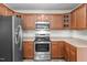 Kitchen showcasing stainless steel appliances, including a refrigerator, microwave, and oven, with wooden cabinetry at 1106 Lake Ridge Dr, Creedmoor, NC 27522