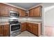 A cozy kitchen with wood cabinets, stainless steel appliances, and ample counter space for culinary creations at 1106 Lake Ridge Dr, Creedmoor, NC 27522