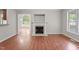 Living room featuring a fireplace and hardwood floors adjacent to an arched doorway leading to another room at 1106 Lake Ridge Dr, Creedmoor, NC 27522