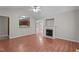 Cozy living room with a fireplace, hardwood floors, and a view into the kitchen, creating an inviting space at 1106 Lake Ridge Dr, Creedmoor, NC 27522