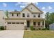 Two-story home with a large front lawn, a two-car garage, and a cozy porch at 1216 Edgemoore Trl, Wake Forest, NC 27587