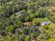 An aerial view shows a home nestled within a lush landscape of trees and lawns at 1318 Indian Camp Rd, Chapel Hill, NC 27516
