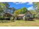Charming home with lush landscaping, a brick pathway, and mature trees on a sunny day at 1318 Indian Camp Rd, Chapel Hill, NC 27516