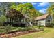 Quaint home with a welcoming front porch, a brick walkway, mature trees, and lovely landscaping at 1318 Indian Camp Rd, Chapel Hill, NC 27516