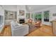 Bright living room featuring fireplace, built-in shelves, comfortable seating, and access to an outdoor deck at 1318 Indian Camp Rd, Chapel Hill, NC 27516