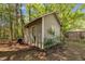 Charming outbuilding with siding and window, nestled amongst trees in the backyard at 1318 Indian Camp Rd, Chapel Hill, NC 27516