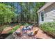 Backyard patio with table and chairs in a wooded setting, ideal for relaxation at 1318 Indian Camp Rd, Chapel Hill, NC 27516