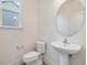 Elegant powder room features a modern pedestal sink, toilet, and a round decorative mirror at 138 Alden Way, Angier, NC 27501