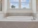 Relaxing bathroom with a soaking tub and a view of blue skies and trees at 138 Alden Way, Angier, NC 27501