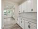 Kitchen counter with white cabinets, marble countertops, and light wood floors at 138 Alden Way, Angier, NC 27501