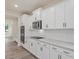 Modern kitchen featuring sleek white cabinets, stainless steel appliances, and a stylish backsplash at 138 Alden Way, Angier, NC 27501
