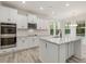 Bright kitchen with stainless steel appliances, granite countertops, a kitchen island and white cabinets at 138 Alden Way, Angier, NC 27501