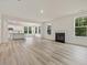 Open-concept living area with fireplace, light floors, and seamless transition to a modern white kitchen at 138 Alden Way, Angier, NC 27501