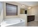Bright bathroom featuring a soaking tub, wood vanity and natural light from window at 138 Horizon Trl, Garner, NC 27529