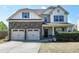 Charming two-story home featuring a two-car garage, stone accents, and manicured landscaping at 138 Horizon Trl, Garner, NC 27529