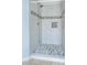 Shower featuring white tiles, mosaic tile floor, and modern shower head at 138 Horizon Trl, Garner, NC 27529