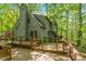 Home back exterior showcasing an expansive wooden deck and gray facade with natural wood railing and sliding glass door at 158 Poplar St # A, Chapel Hill, NC 27516