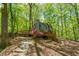 Exterior of a home with a large wooden deck, nestled in a lush, wooded setting, with vibrant green foliage at 158 Poplar St # A, Chapel Hill, NC 27516
