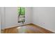 Bright bedroom featuring hardwood floors and a large window with views of the surrounding greenery at 158 Poplar St # A, Chapel Hill, NC 27516