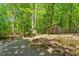 Exterior view of a wooded cabin, with a gravel drive and small footbridge at 158 Poplar St # A, Chapel Hill, NC 27516