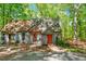 Inviting home exterior featuring a wooden walkway to the orange front door, surrounded by lush greenery and trees at 158 Poplar St # A, Chapel Hill, NC 27516