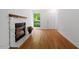 Living room with fireplace, hardwood floors, and bright window at 158 Poplar St # A, Chapel Hill, NC 27516