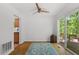Bright living room featuring wood floors, a ceiling fan, a sliding glass door to the deck, and access to the dining area at 158 Poplar St # A, Chapel Hill, NC 27516