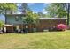 Backyard showcasing the house, mature trees, lush green lawn, patio, and seasonal plants at 1636 Cone Ave, Apex, NC 27502