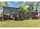 Spacious backyard with a patio, mature trees, lush lawn, and a glimpse of the home's exterior at 1636 Cone Ave, Apex, NC 27502