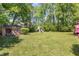 Large backyard with a shed, playground, tall trees, and a manicured lawn, great for outdoor activities at 1636 Cone Ave, Apex, NC 27502