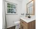 Bathroom featuring wood-look vanity, black hardware, and a window that lets in plenty of natural light at 1636 Cone Ave, Apex, NC 27502