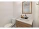 Clean bathroom features a sink vanity with a modern faucet, a framed mirror, and a toilet at 1636 Cone Ave, Apex, NC 27502