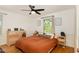 Cozy bedroom features a ceiling fan, window view, and stylish decor on light-colored walls at 1636 Cone Ave, Apex, NC 27502