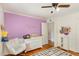 Charming Bedroom with lilac accent wall, rocking chair, and decorative name display above changing table at 1636 Cone Ave, Apex, NC 27502