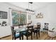 Bright dining room featuring a modern light fixture, wood floors, and a large window offering natural light at 1636 Cone Ave, Apex, NC 27502