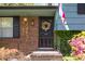 Inviting front entrance with brickwork, flowering plants, and a decorative wreath at 1636 Cone Ave, Apex, NC 27502