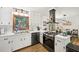 Bright kitchen featuring white cabinets, stainless steel appliances, subway tile, and an open layout connecting to the dining area at 1636 Cone Ave, Apex, NC 27502