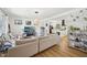 Cozy living room with hardwood floors, a large sofa, and open access to kitchen area at 1636 Cone Ave, Apex, NC 27502