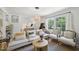 Bright and airy living room with comfortable seating, a round wooden coffee table and hardwood floors at 1636 Cone Ave, Apex, NC 27502