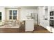Bright kitchen boasts an island with seating, stainless appliances, and a dining area with hardwood floors at 1645 Goldfinch Perch Ln, Knightdale, NC 27545