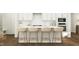 Bright kitchen boasts a breakfast bar with seating, white cabinetry, and stainless steel appliances at 1645 Goldfinch Perch Ln, Knightdale, NC 27545