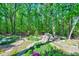 Lush backyard featuring verdant landscaping, flowering bushes, and a meandering stone path at 1715 Us 15-501 S, Chapel Hill, NC 27517