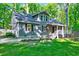 Charming home featuring a covered porch, black shutters, and a lush green lawn with mature trees at 1715 Us 15-501 S, Chapel Hill, NC 27517