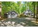 The gray house is complemented by a detached two car garage and a gravel driveway with some natural landscaping at 1715 Us 15-501 S, Chapel Hill, NC 27517