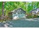 View of the two car garage with horizontal siding, white doors, and windows located on a gravel driveway at 1715 Us 15-501 S, Chapel Hill, NC 27517